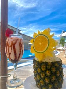 拉巴拉德纳圣安东尼奥Paraiso Barra Hotel的一边享用饮品,一边在桌子上一边欣赏风景,一边品尝 ⁇ 萝