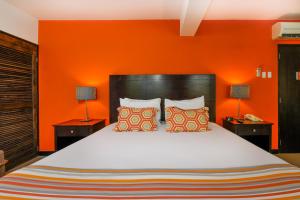 奥拉涅斯塔德城镇讲谈海滩俱乐部酒店的一间卧室配有一张带橙色墙壁的大床