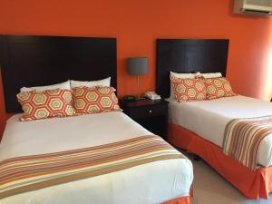 奥拉涅斯塔德城镇讲谈海滩俱乐部酒店的橙色墙壁的酒店客房内的两张床