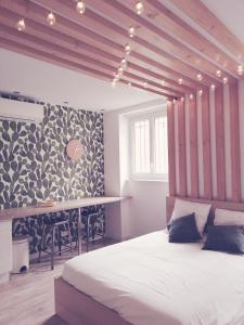 勒克佐Suite 24 Appart'hôtel-3 étoiles的一间卧室配有一张大床和一张桌子