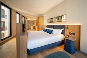 马德里Ocean Drive Madrid的酒店客房设有一张大床和一张桌子。