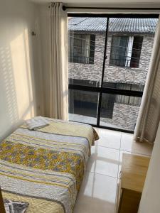 马尼萨莱斯Luxury Hostal的一间卧室设有一张床和一个大窗户
