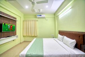 耶拉汉卡RedKEY Inn Bangalore Airport的卧室配有一张床铺,墙上配有电视