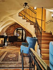 班斯卡 - 什佳夫尼察Hotel Glaus的客厅设有楼梯和蓝椅