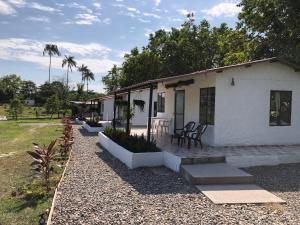 比亚维森西奥Cabañas Campestres en Villavicencio的白色的房子设有庭院和桌椅