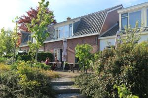 滨海卡特韦克B&B - Pension Het Oude Dorp的花园里有人坐在桌子旁的房子