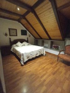 别尔萨Apartamentos Sorripas 2 hab的一间卧室配有一张床,铺有木地板