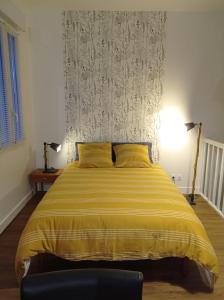 利布尔讷Le Girond'Inn的一间卧室配有一张带黄色毯子的大床