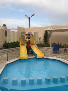 赫尔格达Serenity Home Hurghada的度假村内带充气滑梯的游泳池