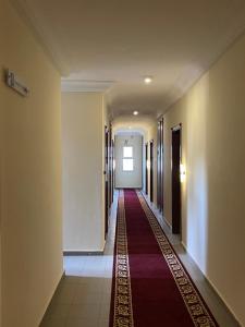 雅温得LA ROCHELLE HOTEL的大楼里长长的走廊,有红地毯