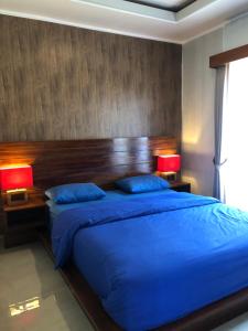 贝都古BUYAN LODGE lake view villa的一间卧室配有一张带两盏灯的大蓝色床。