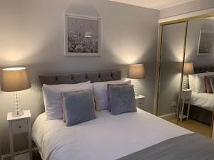 艾尔Kinfirth Apartment的一间卧室配有一张带两盏灯的大型白色床。