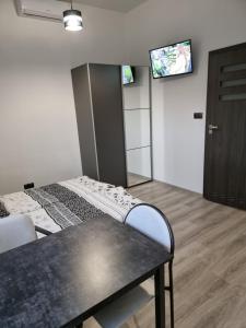 库特诺Noclegi 24/h Leszczynek的客房设有两张床、一张桌子和一台电视机。