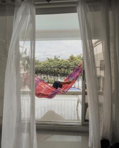 梅尔加Hotel Cacique Guaicani的睡在阳台上吊床上的人