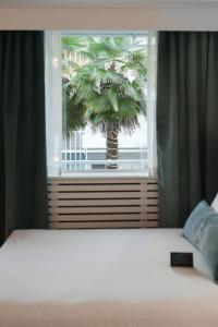 温哥华波拉德酒店的卧室配有床,窗户外有棕榈树