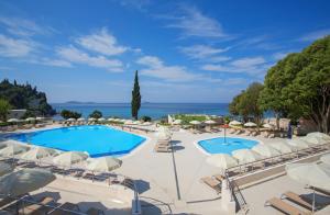 米利尼Maistra Select Astarea Hotel的享有带椅子和遮阳伞的度假村的游泳池景致