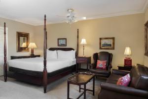 查尔斯顿英迪格酒店的一间卧室配有一张床、两把椅子和一张沙发