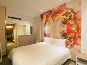 台北Artinn藝築文旅-台北站前館的卧室配有白色的床和墙上的绘画作品