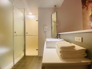 台北Artinn藝築文旅-台北站前館的浴室配有水槽、淋浴和毛巾