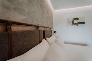 贝尔格拉诺将军镇Böden Hotel & Spa by AKEN Soul的一张带白色枕头的木制床头板的床