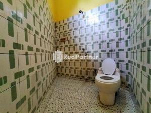 BaubauHotel Hing Amimah Mitra RedDoorz的瓷砖墙内带卫生间的浴室