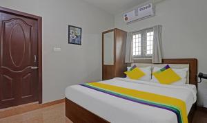 钦奈Itsy Hotels Rithika Inn Blossoms的一间卧室配有一张大床和色彩缤纷的毯子