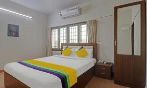 钦奈Itsy Hotels Rithika Inn Blossoms的一间卧室配有一张带彩虹毯子的床