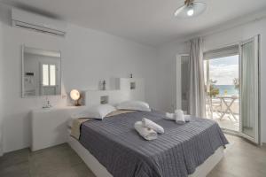 Agia Kiriaki BeachAqua Bay Agia Kyriaki的白色卧室,配有带毛巾的床