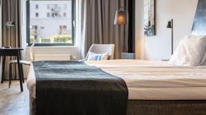 哥德堡艾瑞克斯伯莎伦11号品质酒店的配有一张床、一张书桌和一扇窗户的酒店客房