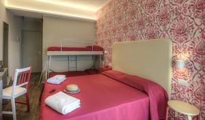 里米尼Hotel 2000的一间卧室配有一张红色的床、椅子和双层床