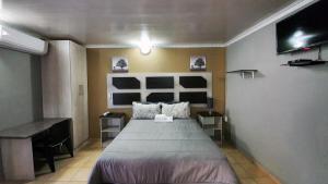 布隆方丹Genesis Self Catering Apartments的一间卧室配有一张大床和一张书桌