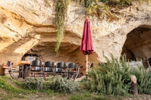 卡拉讷B&B Bacchus Grotto with only 1 suite 45m2 plunge pool privé的洞穴里的桌椅和雨伞