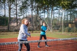 圣彼得奥尔丁campushus的两名年轻人在网球场打网球