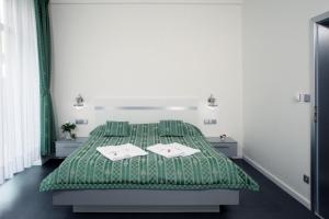 布拉格优卡拉酒店的一间卧室配有绿床和2条毛巾