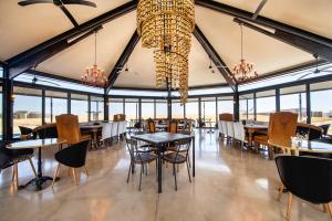 OmuthiyaEtosha King Nehale的用餐室配有桌椅和吊灯。