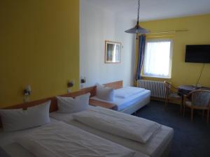 柏林Hotel Süden的一间酒店客房,设有两张床和电视
