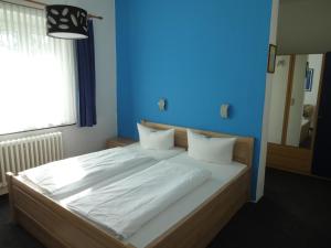 柏林Hotel Süden的一间卧室设有一张蓝色墙壁的大床