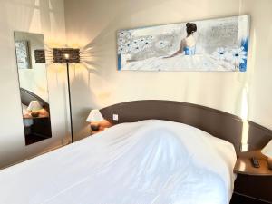 IsberguesHôtel - Restaurant "Histoire de Bistrot"的卧室配有白色的床和墙上的绘画作品