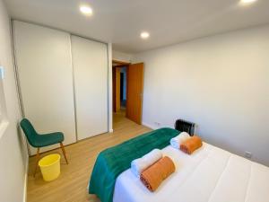 大里贝拉Baía dos Moinhos的一间卧室配有一张床和一把绿色椅子