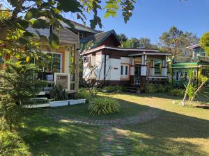 莫拉限มุกดาสวรรค์ รีสอร์ท - Mukda Sawan Resort的前面有花园的房子