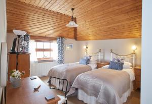 HicklingDairy Barns的一间卧室设有两张床和木制天花板