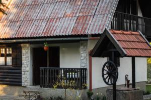 代尔尼采Kuća za odmor Curl的一间有锈蚀屋顶和轮子的小房子