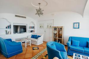 切塔拉塞图斯酒店的客厅配有蓝色椅子和电视