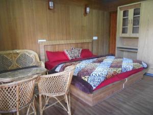 乔斯希马特Nandan Kanan Auli Resort的卧室配有一张床和一张桌子及椅子