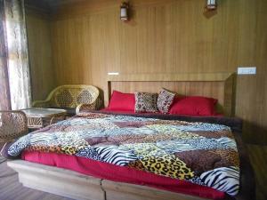 乔斯希马特Nandan Kanan Auli Resort的一张大床,上面有五颜六色的毯子