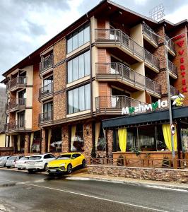 埃斯托萨多克VERTEX SPA hotel的停在大楼前的黄色汽车