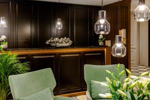 布达佩斯Budapest Eye- Boutique Suites, by BQA的用餐室配有2把绿色椅子和灯