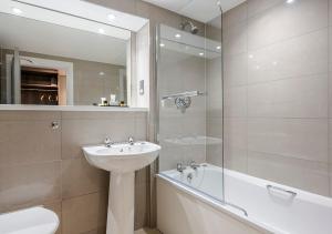 法纳姆霍格巴克Spa酒店的浴室配有盥洗盆、卫生间和浴缸。