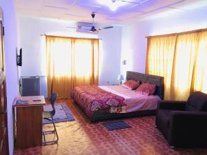 阿克拉Feel At Home & be close to the Labadi Beach (5min)的一间卧室配有一张床、一张桌子和一张沙发