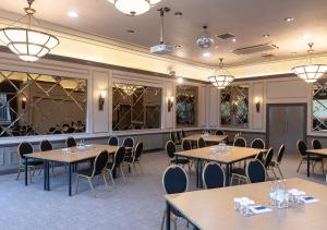 法纳姆霍格巴克Spa酒店的用餐室设有桌椅和窗户。